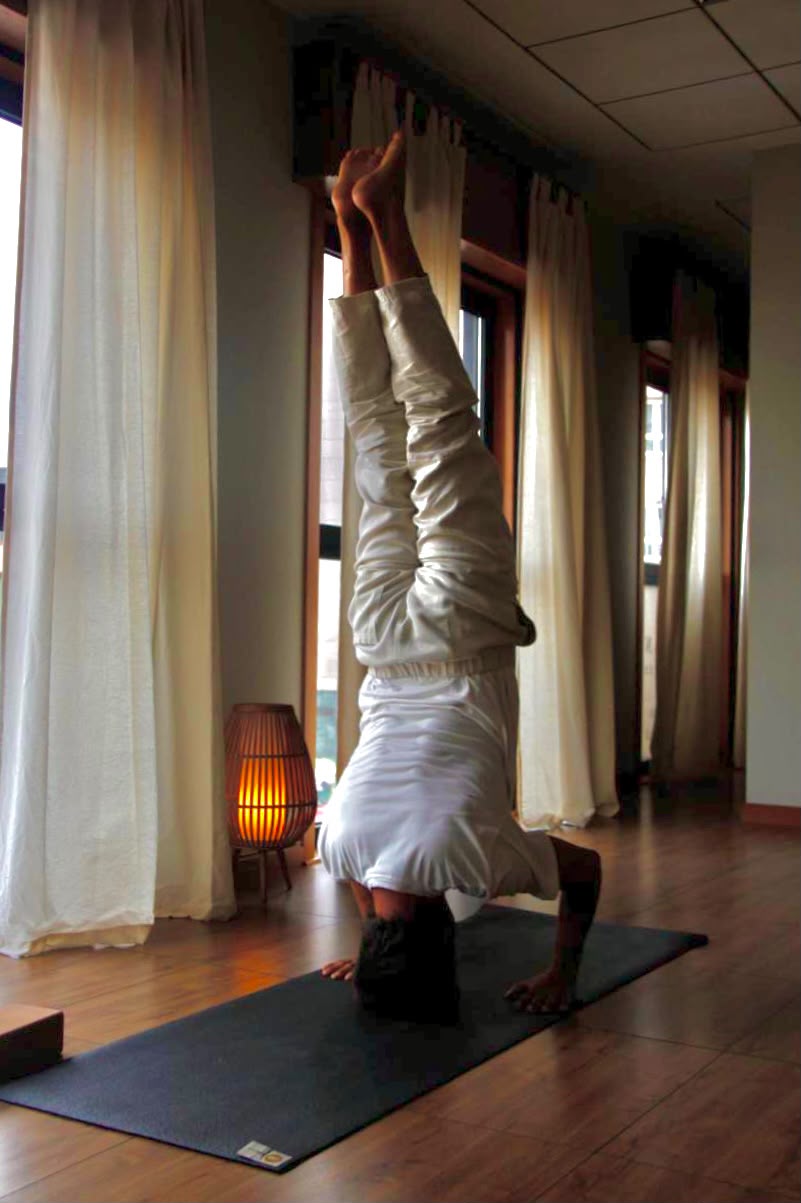 Profesor de yoga practicando junto a la ventana en Emana Yoga Carballo