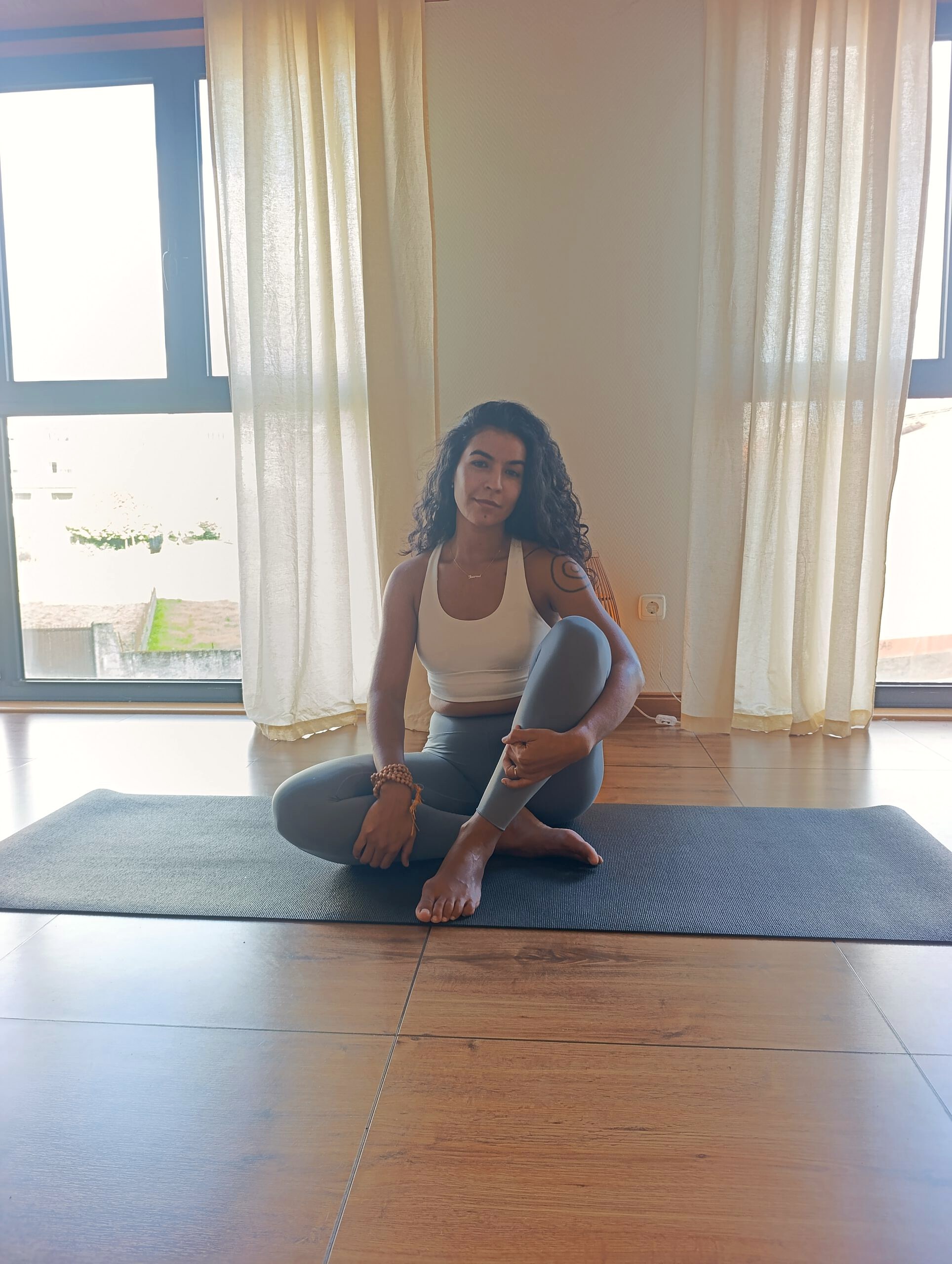 Profesora de yoga sentada sobre la esterilla en Emana Yoga Carballo