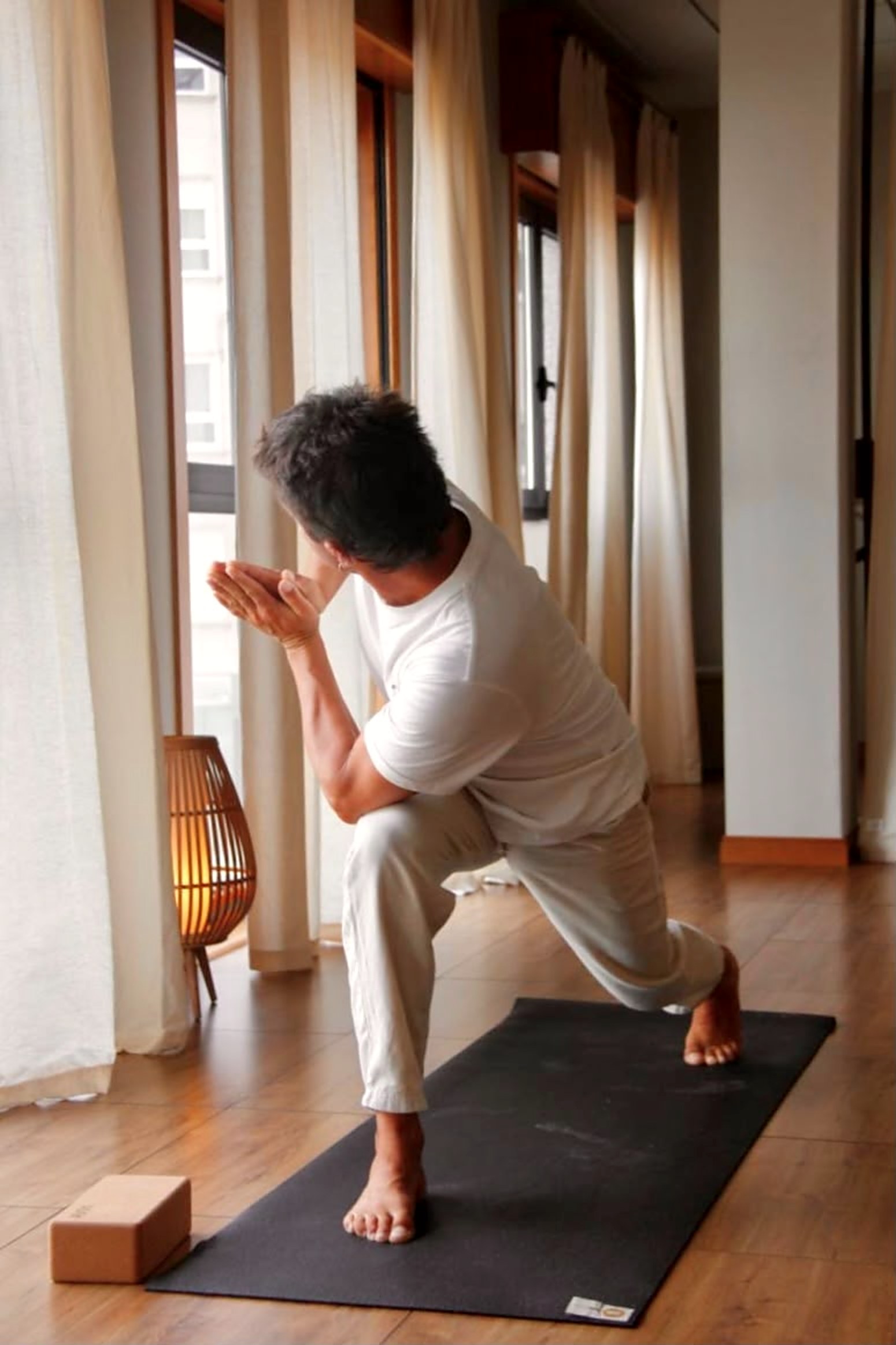 Profesor de yoga practicando junto a la ventana en Emana Yoga Carballo